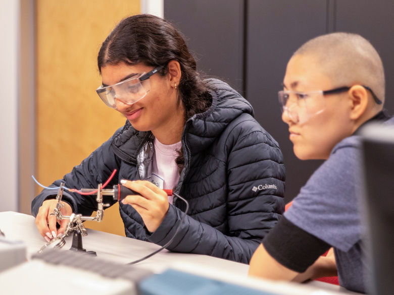 Two students soldering in engineering lab