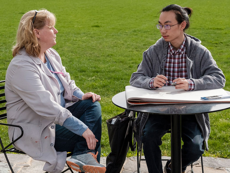 Student and professor discussing in the Perkins Plaza