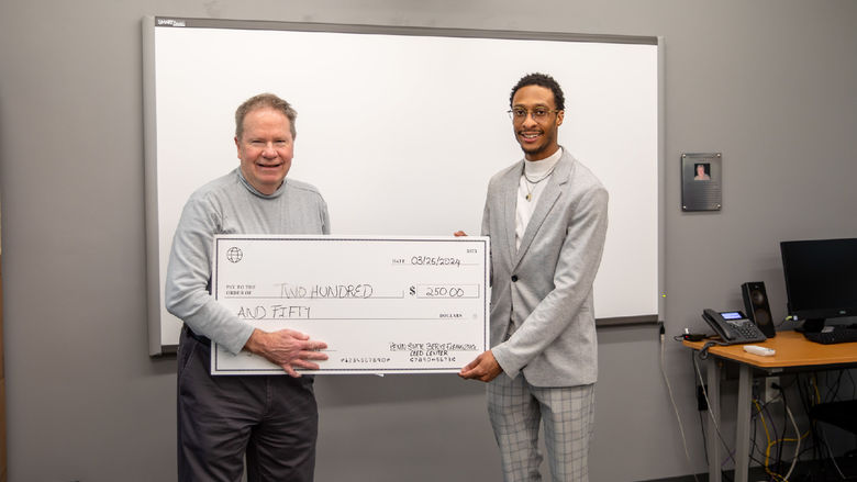 Male student poses with check of $250