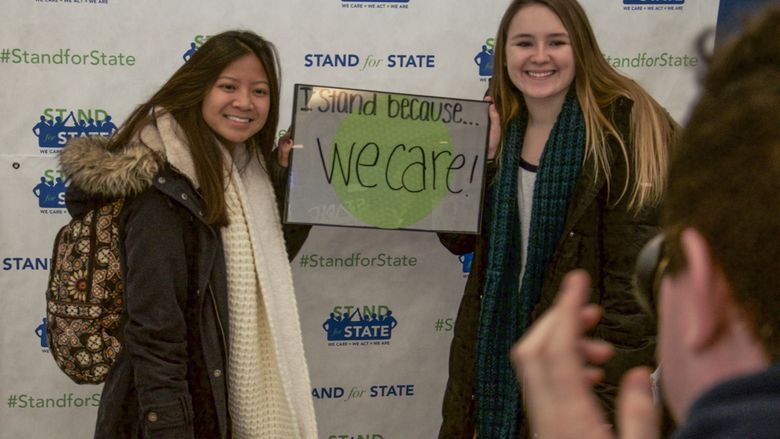 Two students posing with a sign 