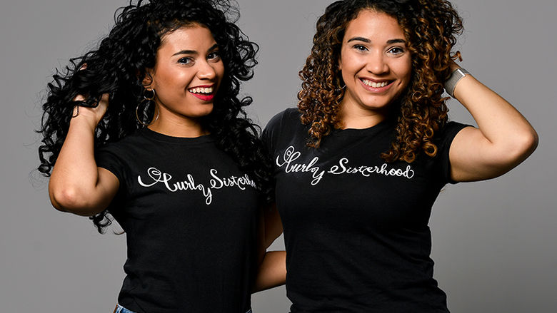 The Varona Sisters pose with their Curly Sisterhood t-shirts.