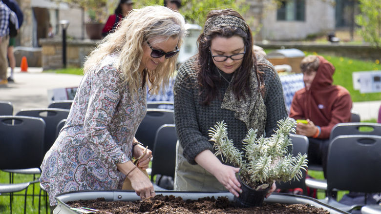Berks staff member and student plant seeds into pot