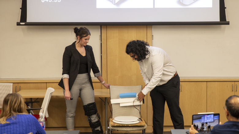 Female and male student present adaptive toilet lid opener 