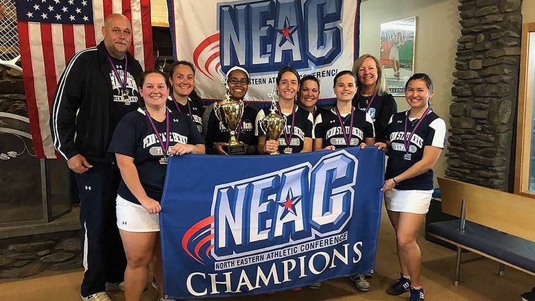 The Berks Women's Tennis team with the NEAC banner