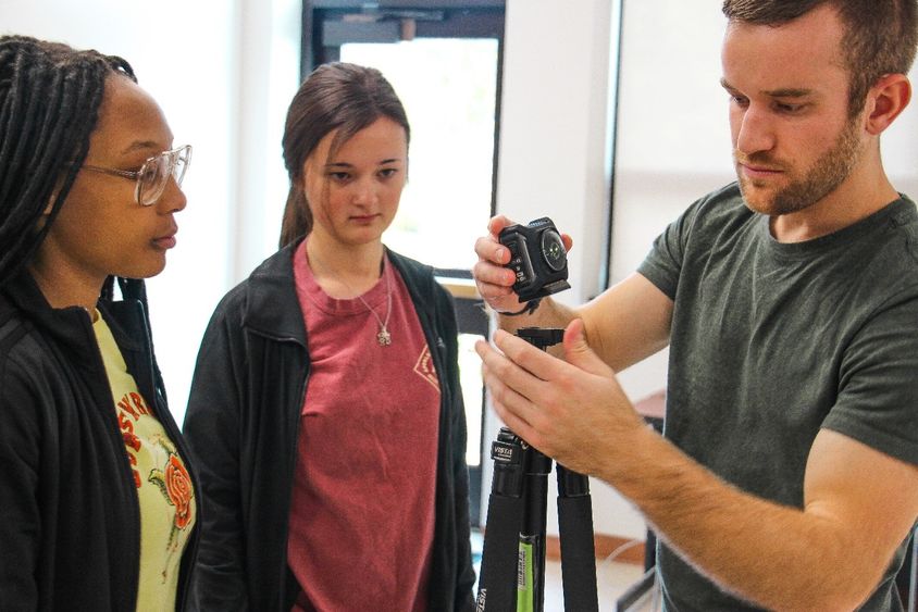 Three students set up 360-degree camera equipment
