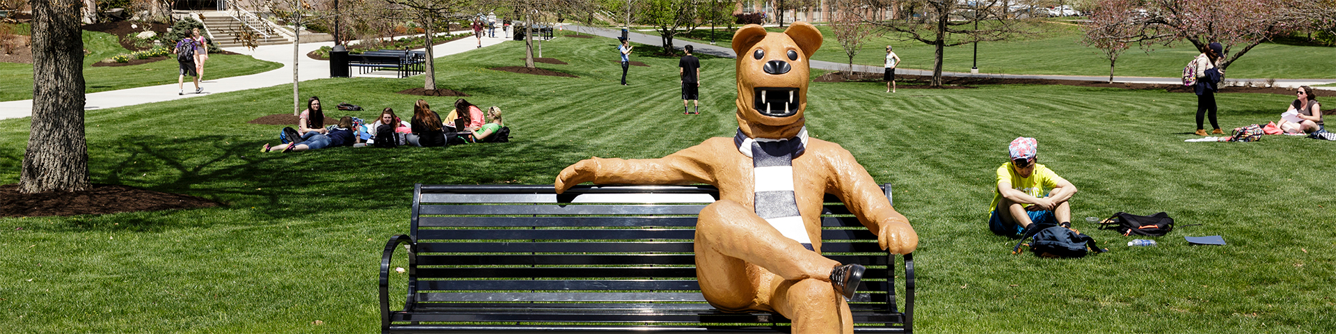 Penn State Berks Lion Bench with students sitting in the grass
