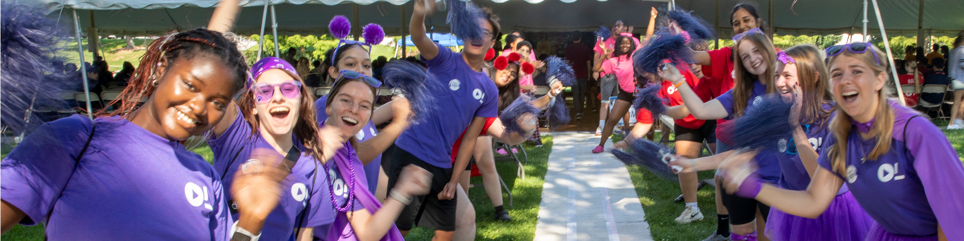 Orientation leaders shake pom poms and noisemakers for new students