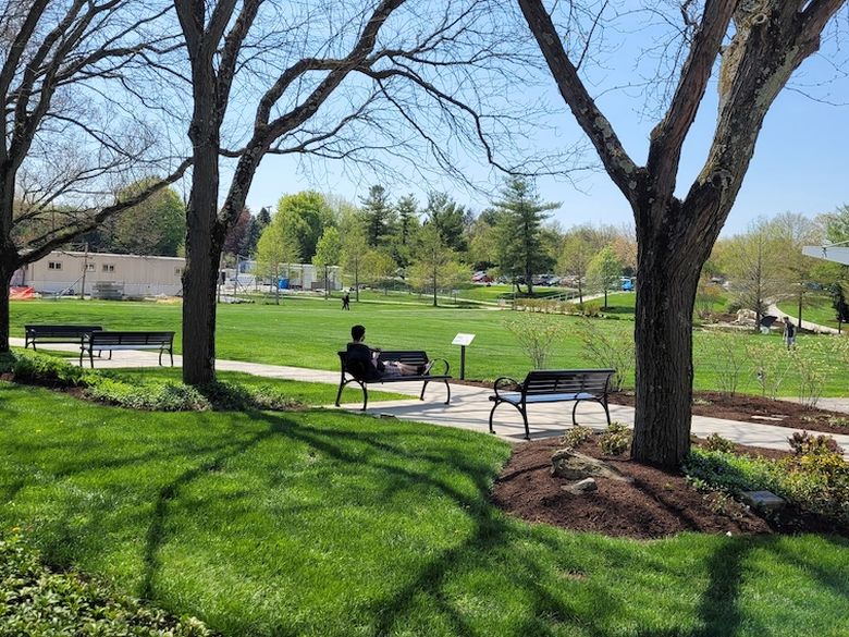 A student relaxes on a bench outside Perkins Student Center