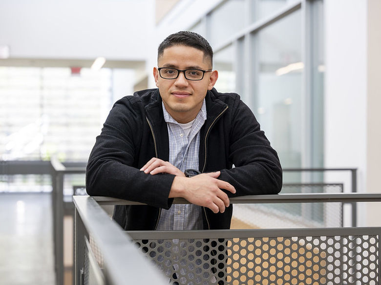 Adult student leans on railing in Gaige Building