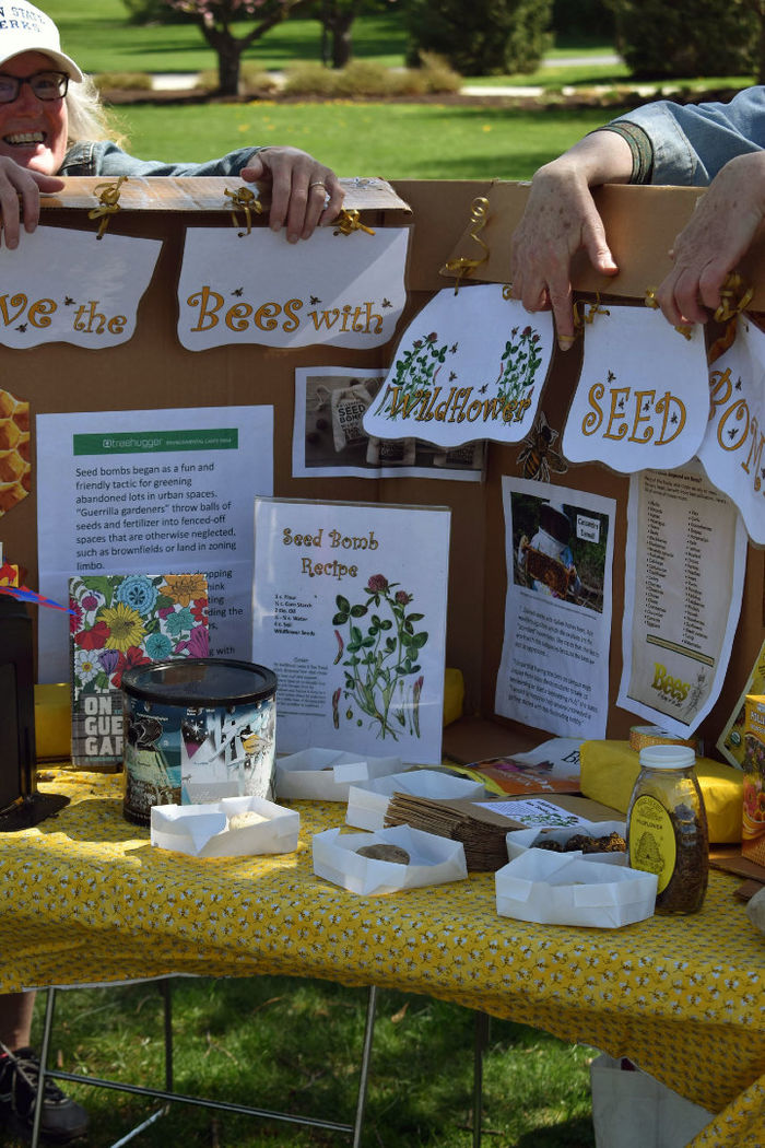 Students hold up an informational sign about bees' role in the ecosystem