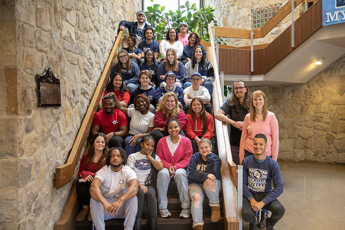 Resident assistants stand on Perkins Student Center stairs for photo