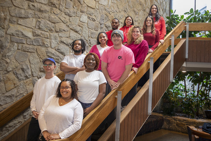 Resident Assistants for The Woods stand on the Perkins Student Center stairs