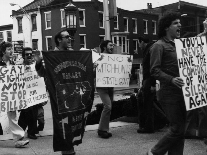 a black and white photo of protesters advocating for LGBTQI+ rights