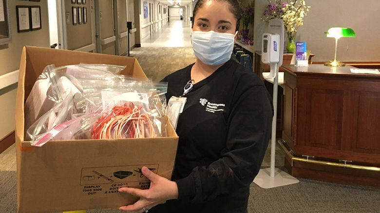 A member from Encompass Health holds the donated face shields.