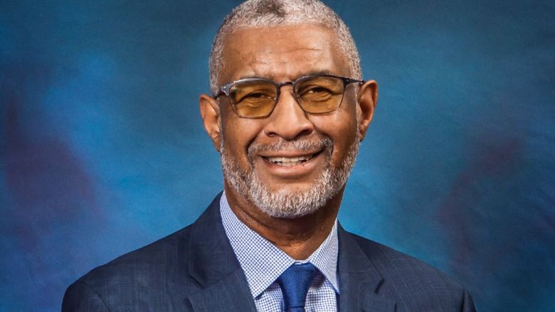 A headshot of Penn State Berks Chancellor George Grant Jr. wearing a blue suit against a blue background.