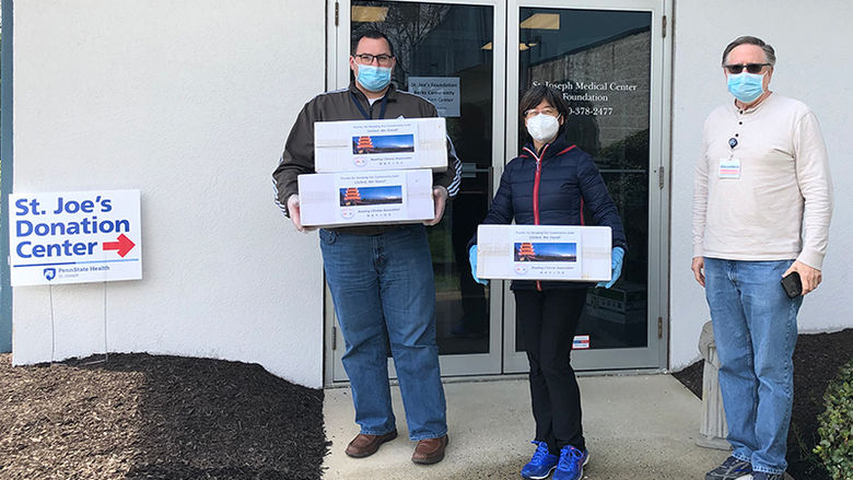 Red Yuan, helps deliver a donation of 1,500 surgical masks.