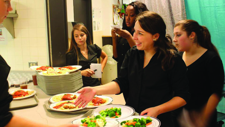 students serving dinner