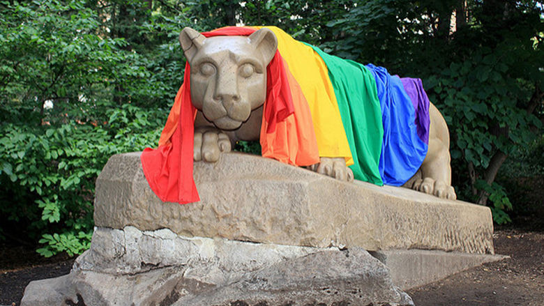 A rainbow pride flag draped over the Nittany Lion.