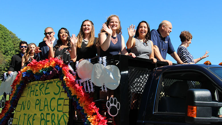 students ride their float in the homecoming parade