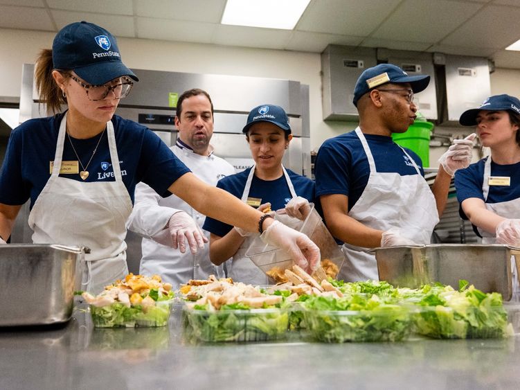 Berks students work in a food serve environment preparing salads as part of a hospitality management course