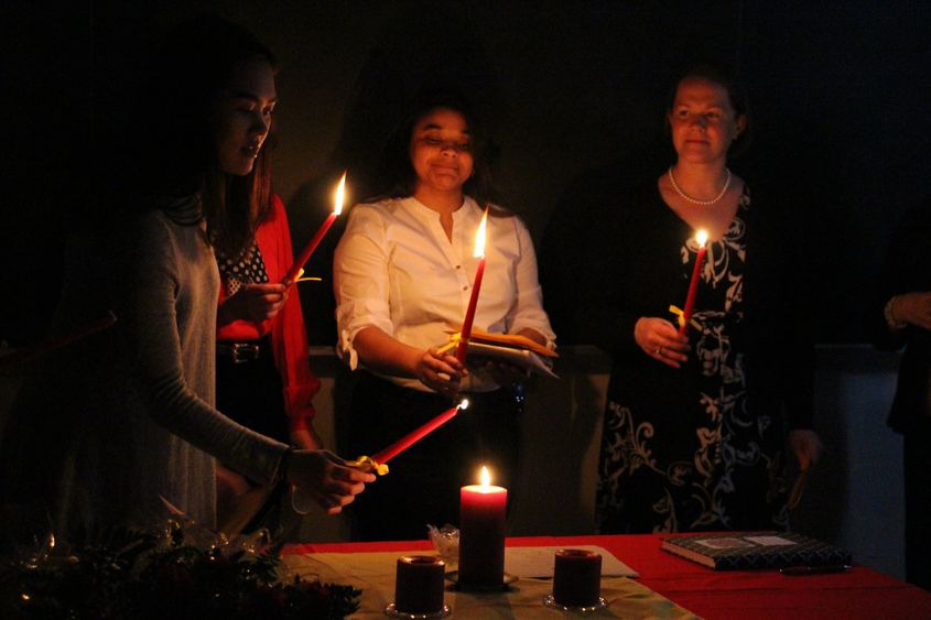 Students light a candle during the induction ceremony for Sigma Delta Pi