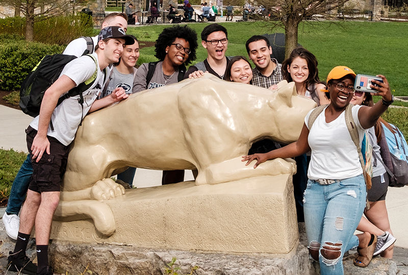 Students taking a selfie in front of the lion shrine.