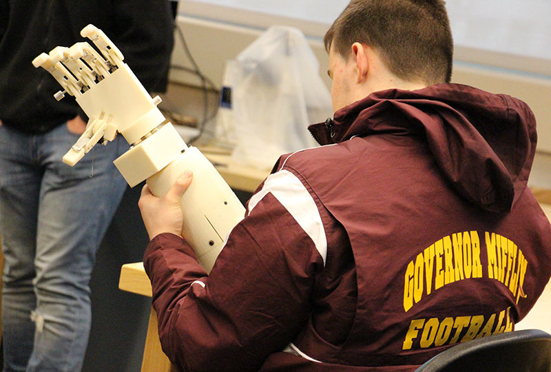 A local high schooler examines a prosthetic arm that was designed by Berks engineering students