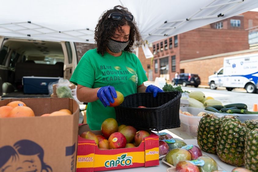 Christina Houston, a staff member of Blue Mountain Academy, arranges produce to be sold at the farm stand at Penn State Health St. Joseph Downtown Campus.