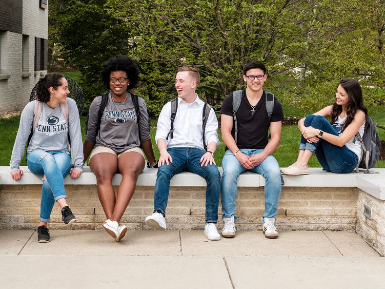 Five student sitting on a wall