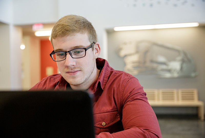Berks student focusing on his studies in the library. 