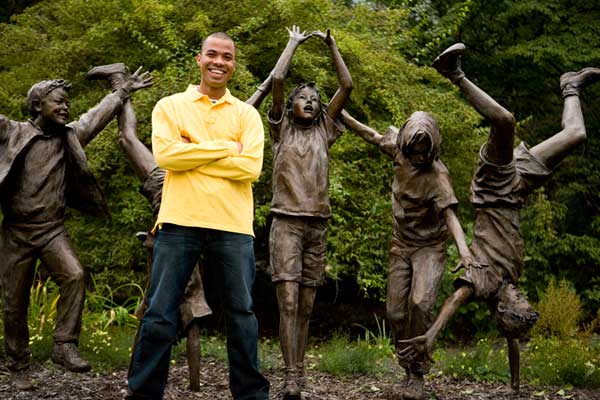 Male student poses with statues