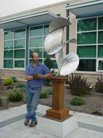 artist Joe Mooney standing by Glide sculture